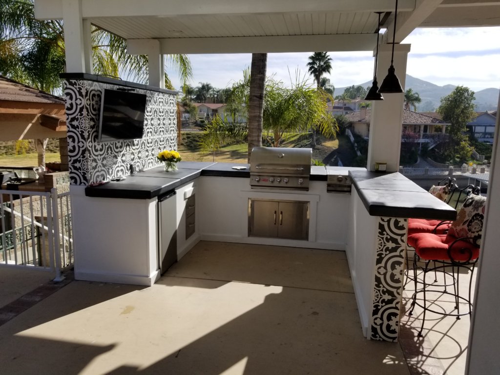 Covered outdoor kitchen with BBQ and bar seating