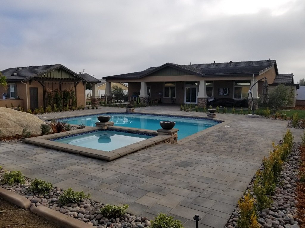 Pool and spa with a wide paver deck