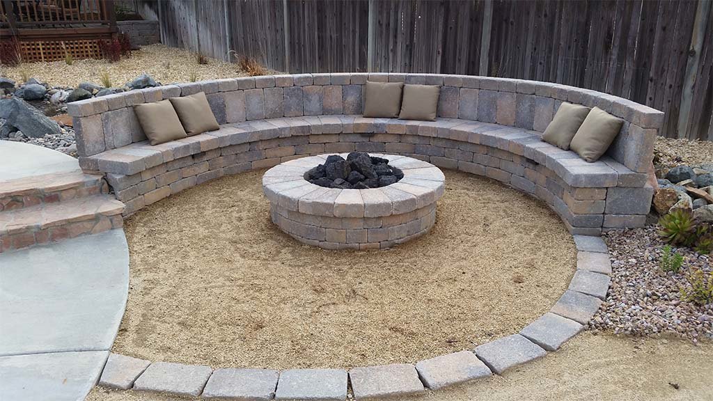 Decomposed granite fire pit with segmented seat wall and paver edge